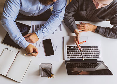 people working together pointing at laptop